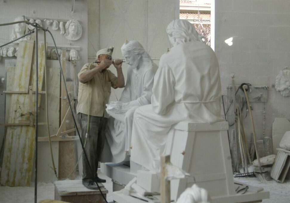 The image below shows a master carver from Pietrasanta with both the plaster carver's model as well as the in process marble sculpture. Notice how St. Joseph's hands are still surrounded in stone. 

